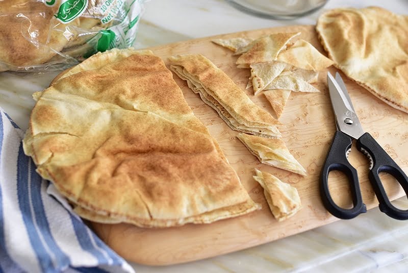 Pita bread is cut in strips with scissors