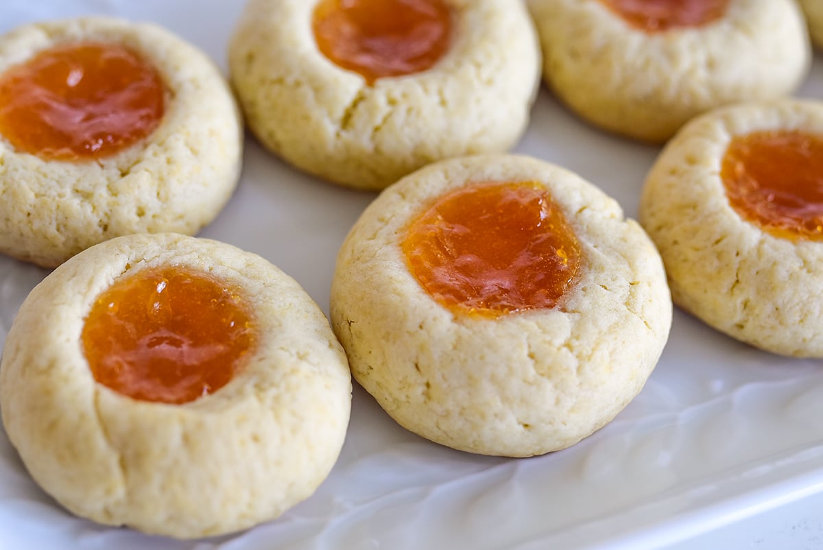 Thumbprint cookies with apricot jam on a white plate