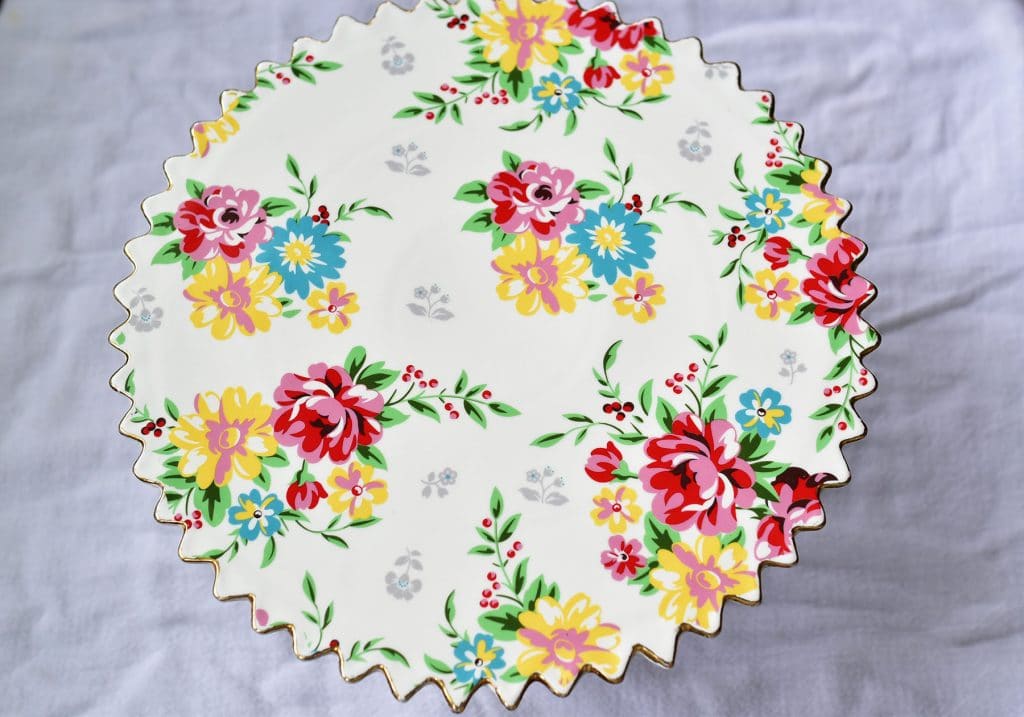 Pedestal cake plate decorated with painted roses in pink, blue, yellow and green