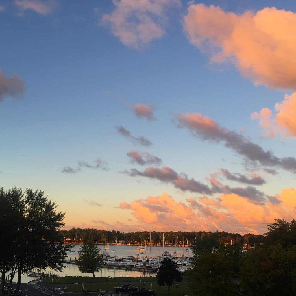 Sunrise over Little Traverse Bay, with pink clouds against a deep blue morning sky