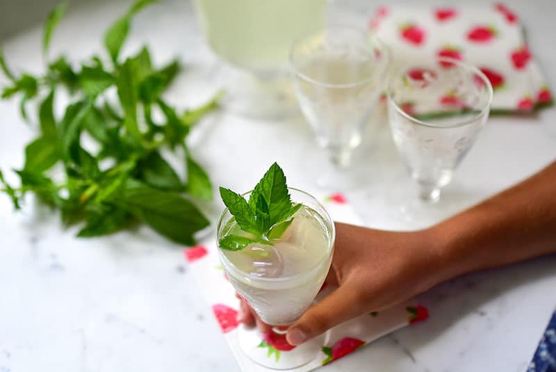 Fresh mint lemonade with mint sprigs and little hand.