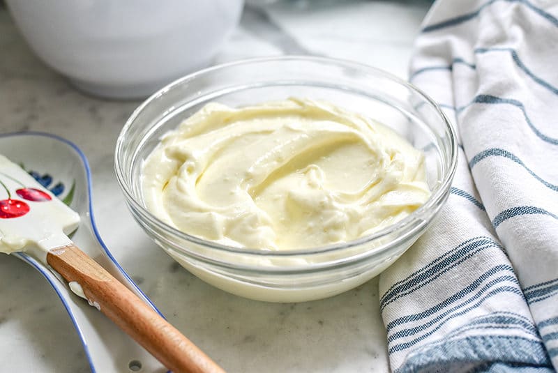 Homemade ashta cream in a glass bowl on a marble countertop.