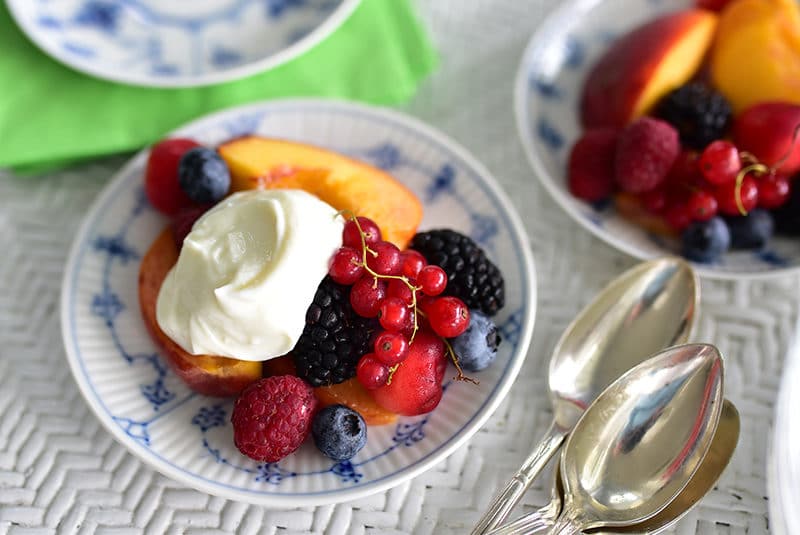 Fresh fruit with ashta cream in a Royal Copenhagen blue dish on a wicker table, Maureen Abood