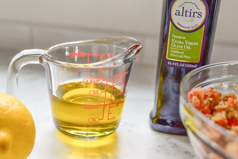 Olive oil in a glass measuring cup with a bottle next to it, Maureen Abood