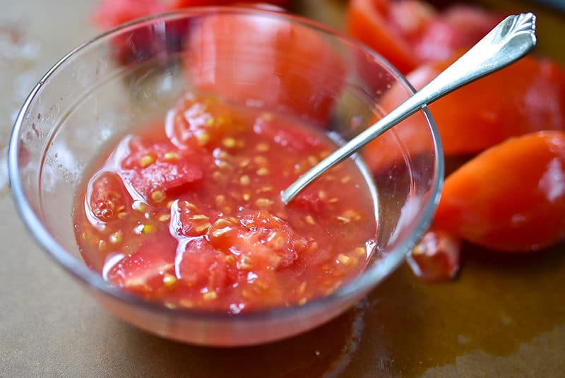 Tomato seeds in a glass bowl with a silver spoon, Maureen Abood