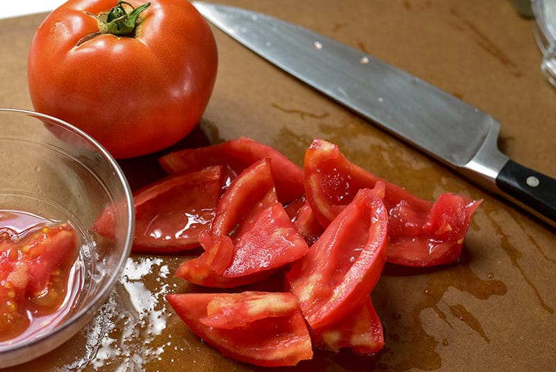 Seeded tomatoes on a cutting board with a sharp knife, Maureen Abood