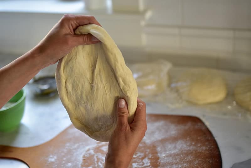 Shaping pizza dough for zaatar flatbread