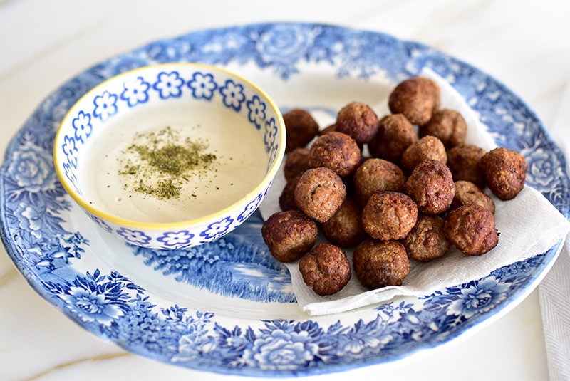 Kibbeh bites on a platter with tahini sauce, Maureen Abood