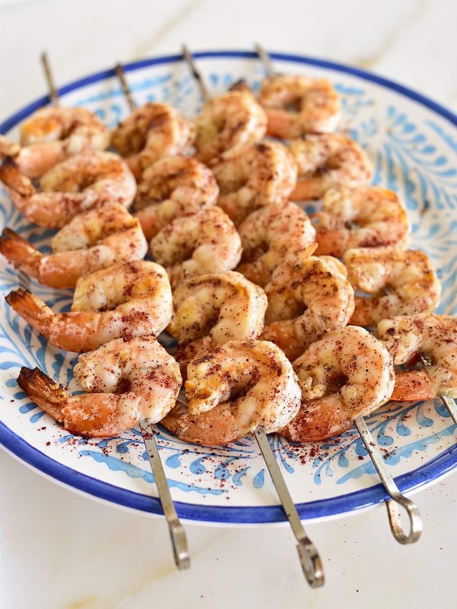 shrimp on skewers on a blue plate
