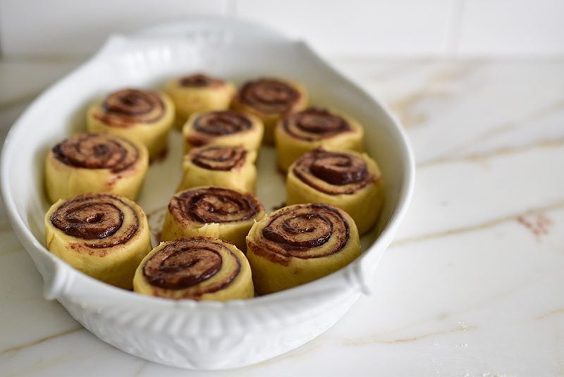 Rolls before the second rise in a baking pan for chocolate tahini breakfast rolls