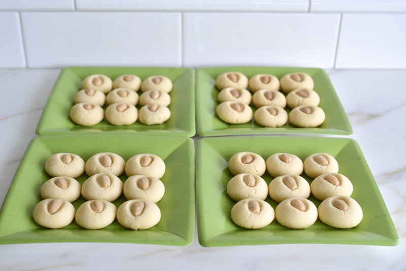 Little white Lebanese almond butter cookies on green paper plates