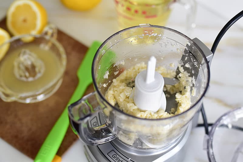 Garlic being processed in a small food processor.