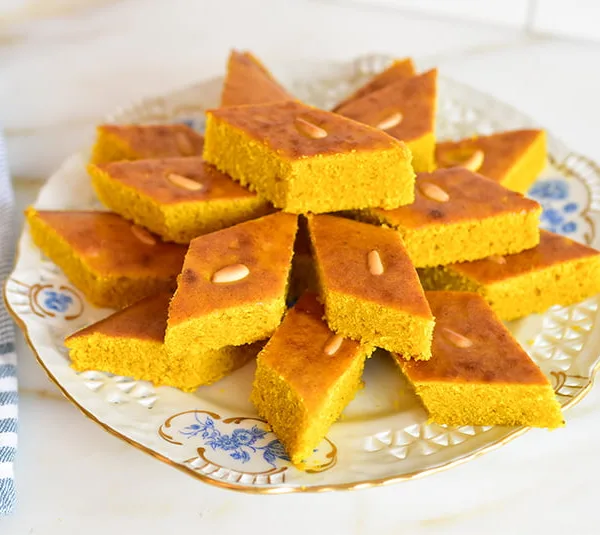 Lebanese Sfouf cake with turmeric cut in diamond-shaped pieces on a white plate