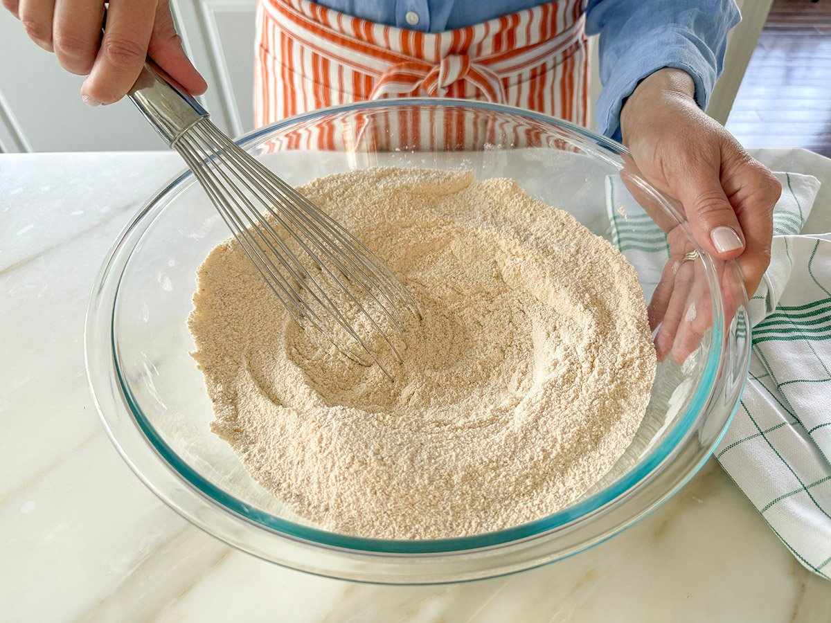 A whisk in a bowl of flour