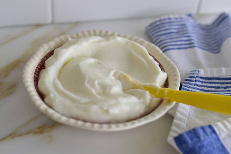 Toum garlic sauce in a dish with yellow spatula