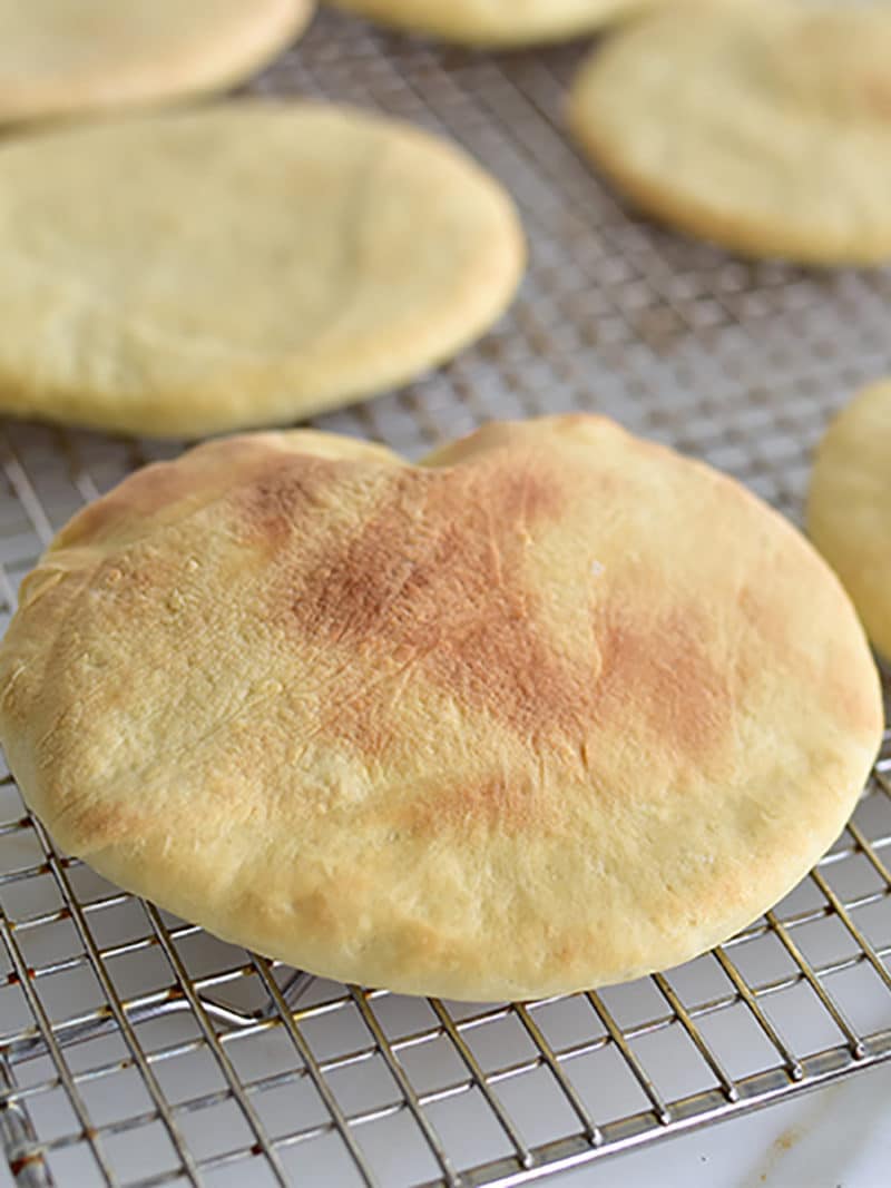 Homemade pita bread on a cooling rack