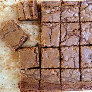 Blondie bars cut in squares on a sheet of parchment paper