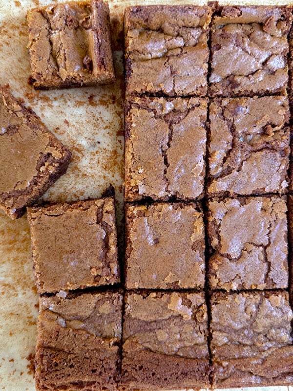 Blondie bars cut in squares on a sheet of parchment paper