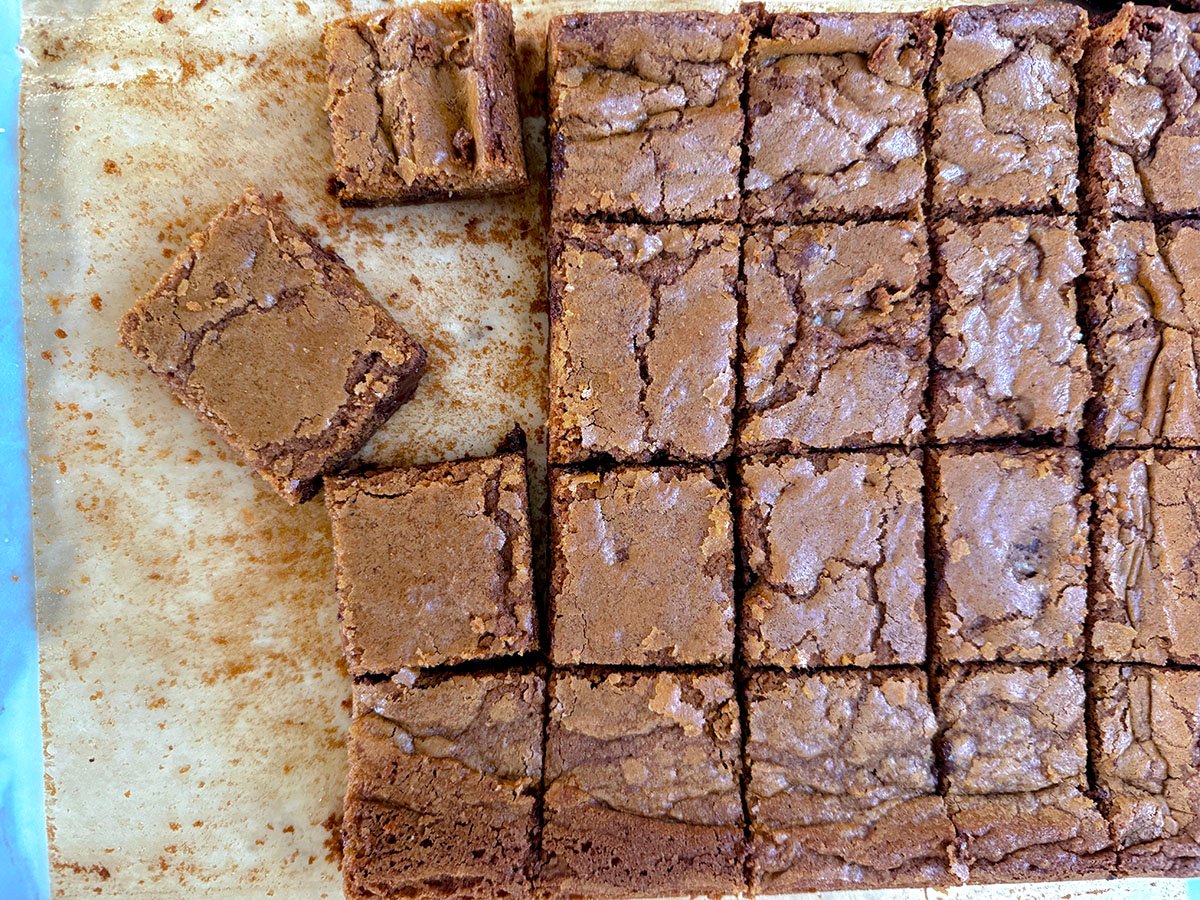 Blondie bars cut in squares on a sheet of parchment paper