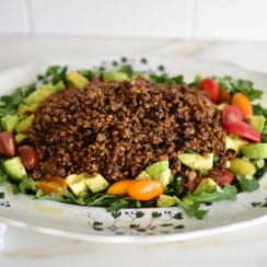 Arugula salad with mujadara on top on a big platter
