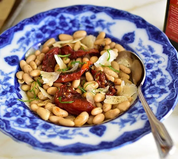 White beans with za'atar roasted tomatoes and olive oil, in a vintage blue pasta bowl