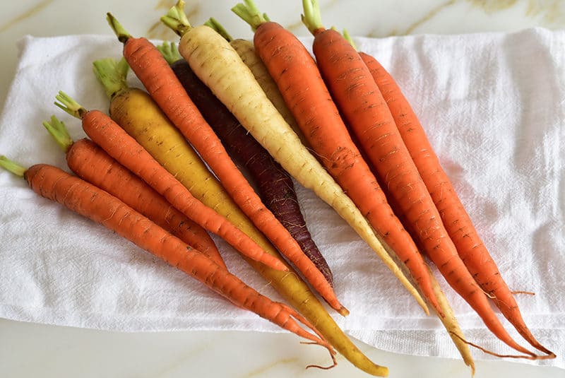 Trimmed carrots on a towel for roasting