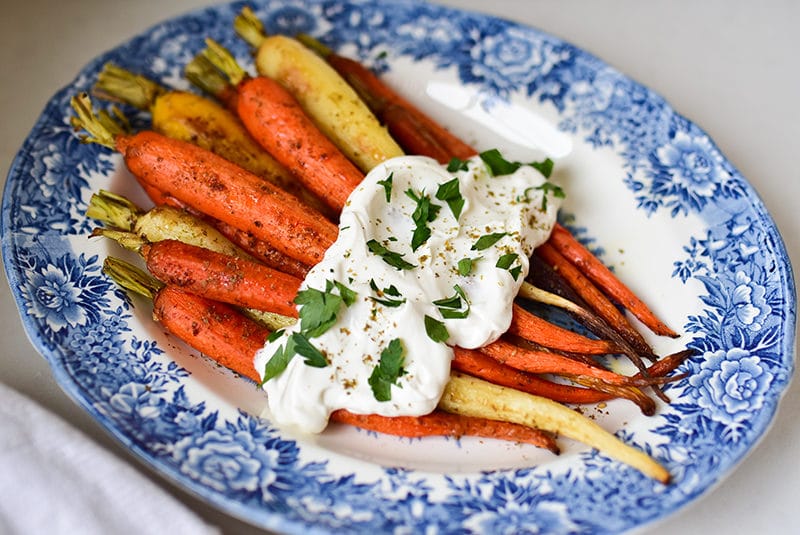 Za'atar roasted carrots with labneh on a blue floral platter