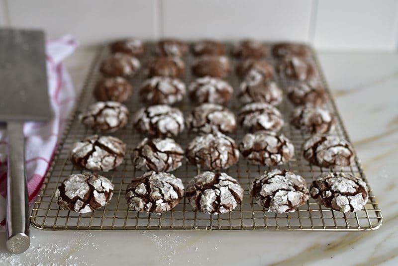 Chocolate crinkle cookies with orange blossom cooling on a rack