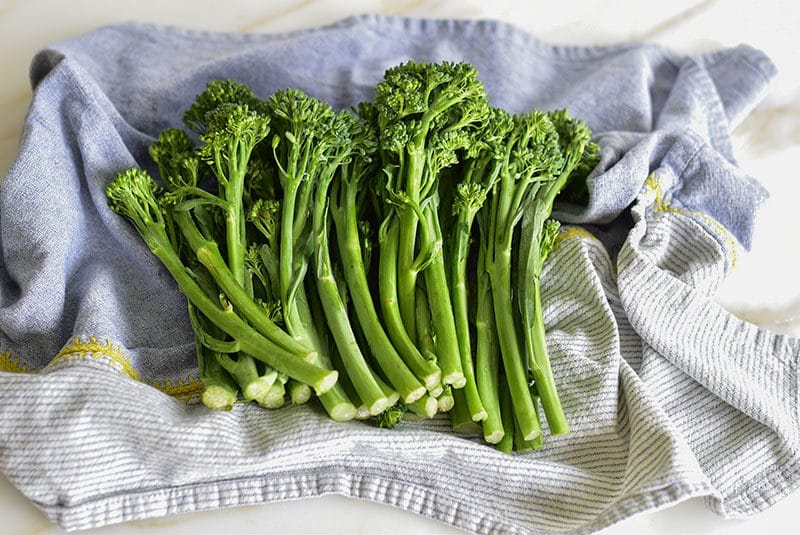 Broccolini drying in a blue towel