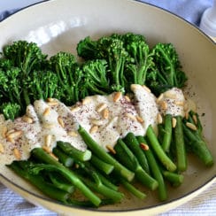 Green Broccolini with Pine Nut Sauce and Sumac in a white enameled dish