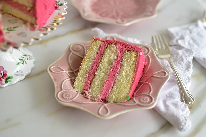 Slice of raspberry buttercream cake on a pink Juliska plate