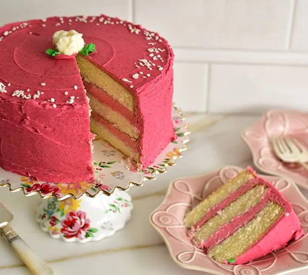 Raspberry buttercream cake slice on a pink plate