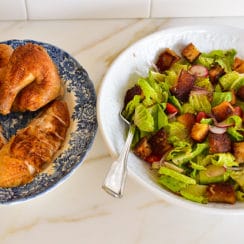 Roasted Chicken on a platter next to a bowl of fattoush salad