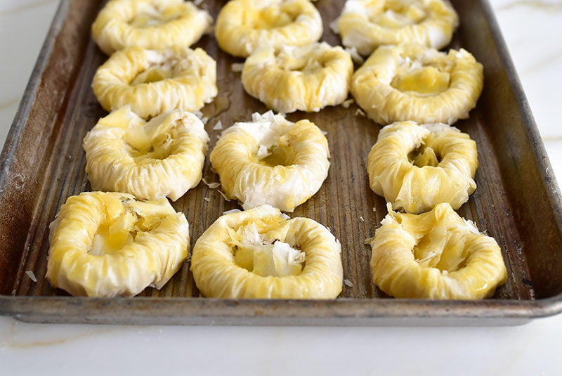 Buttered phyllo nests on a sheet pan before baking