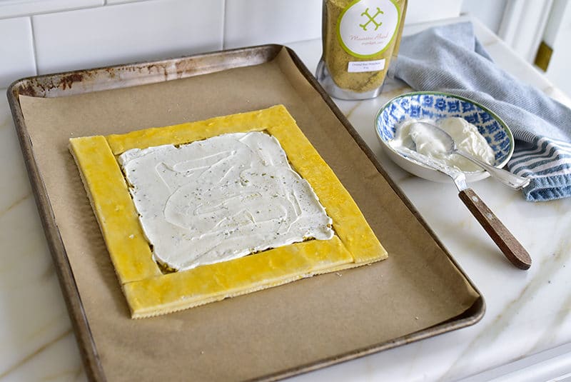 puff pastry on a sheet pan coated with labneh