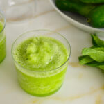 Frozen mint julep in clear glasses with fresh mint and cucumbers in a dish