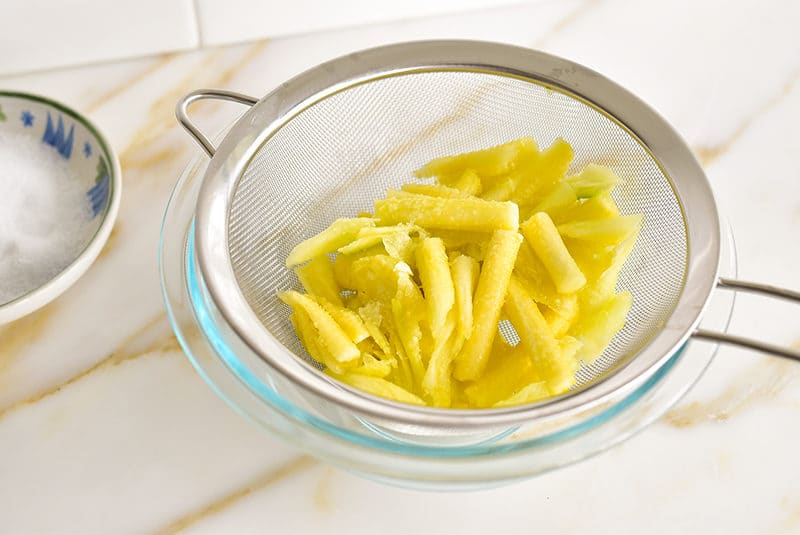 Salted squash cores in a strainer