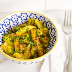 Sauteed squash cores in a little blue and yellow bowl with a fork alongside
