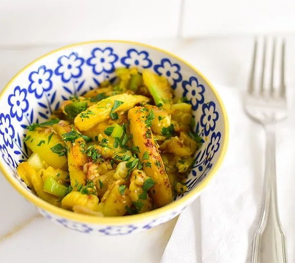 Sauteed squash cores in a little blue and yellow bowl with a fork alongside