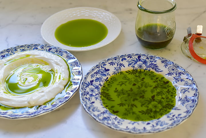 Basil oil in three plates on the counter