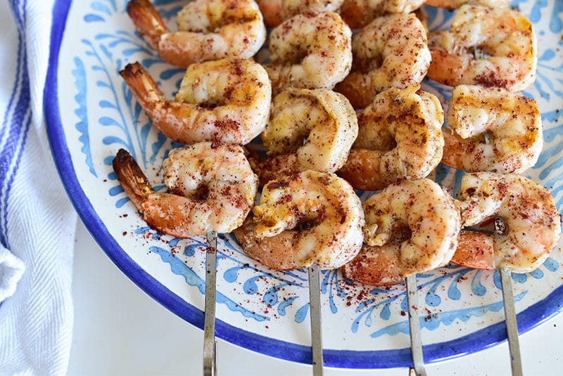Shrimp skewers with sumac, on a blue plate