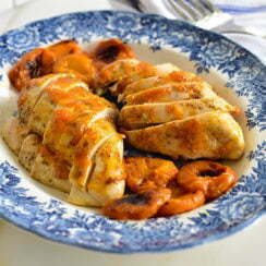 Apricot Chicken sliced with apricots on a blue platter