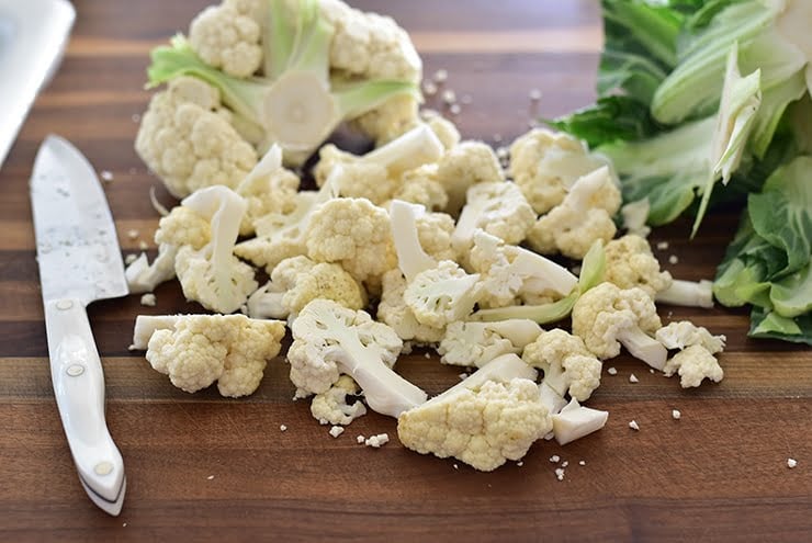 Cauliflower cut in florets on the cutting board with knife
