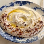 Whipped feta dip with olive oil on top on a blue and white plate