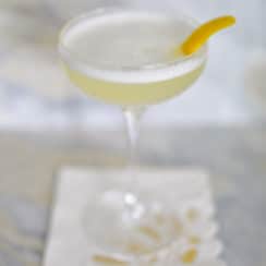 Gin Fizz cocktail in a coupe with lemon twist