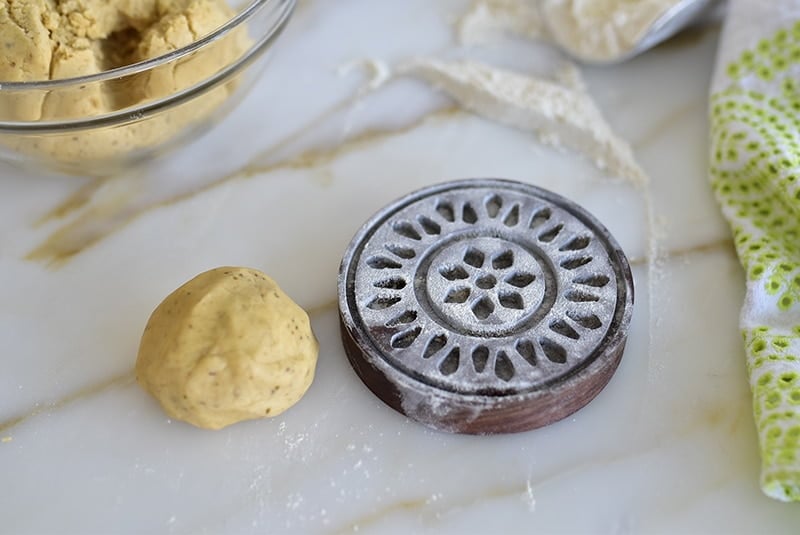 Dough ball with floured wooden cookie mold