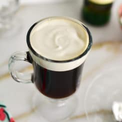 Glass mug of Irish coffee with cream on top