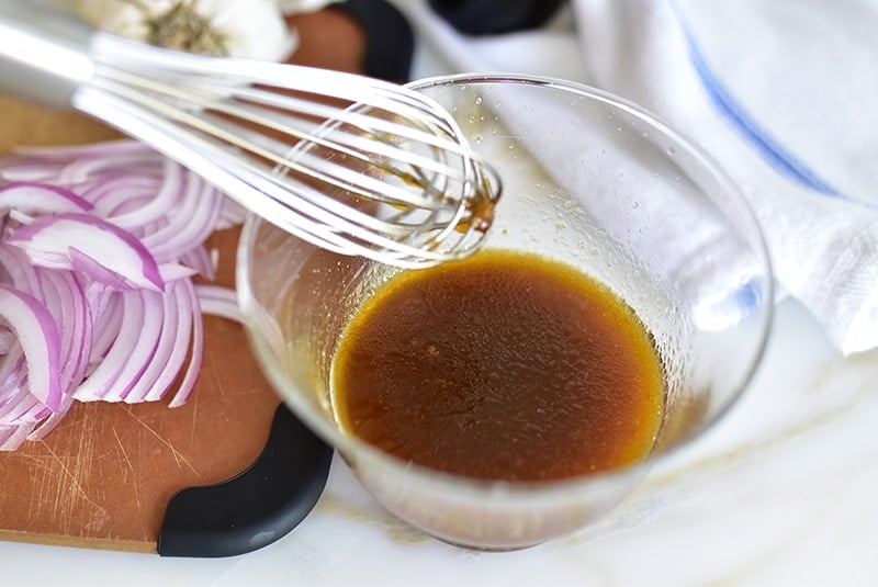 Vinaigrette with a whisk in a glass bowl
