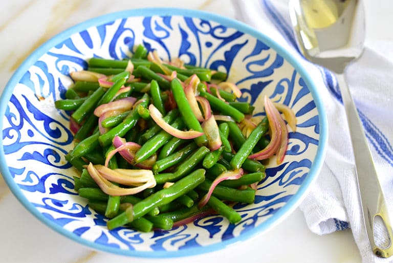 Green beans with onions in a blue bowl