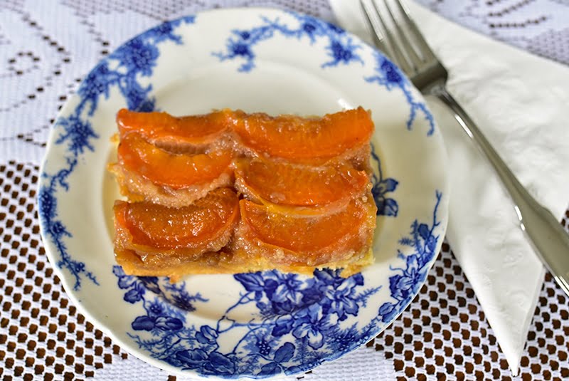 Apricot upside down cake slice on a blue and white plate